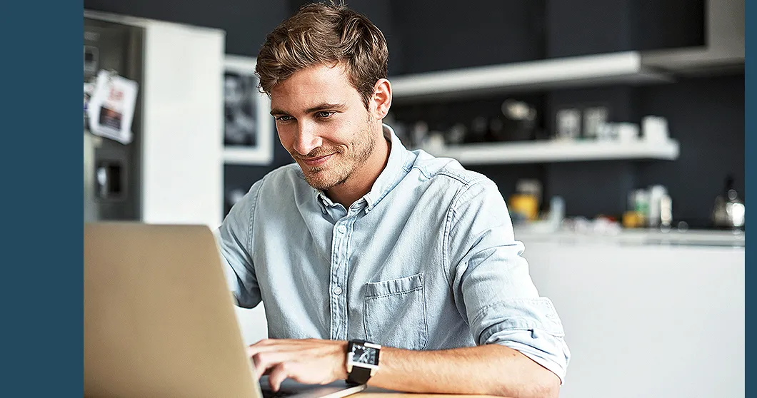 Man with beard looking at a laptop